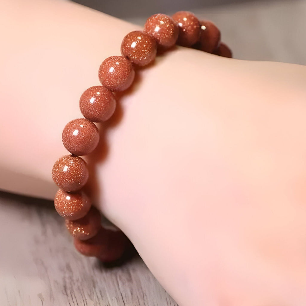 Bracelet mixte en perles rondes de pierre de sable orange scintillante, style naturel et élégant.