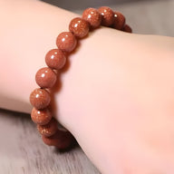 Bracelet mixte en perles rondes de pierre de sable orange scintillante, style naturel et élégant.