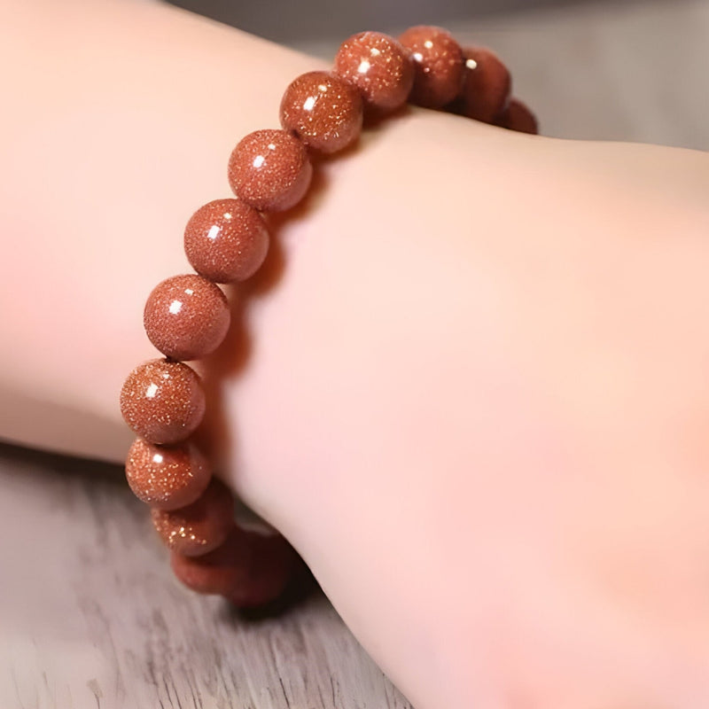 Bracelet mixte en perles rondes de pierre de sable orange scintillante, style naturel et élégant.