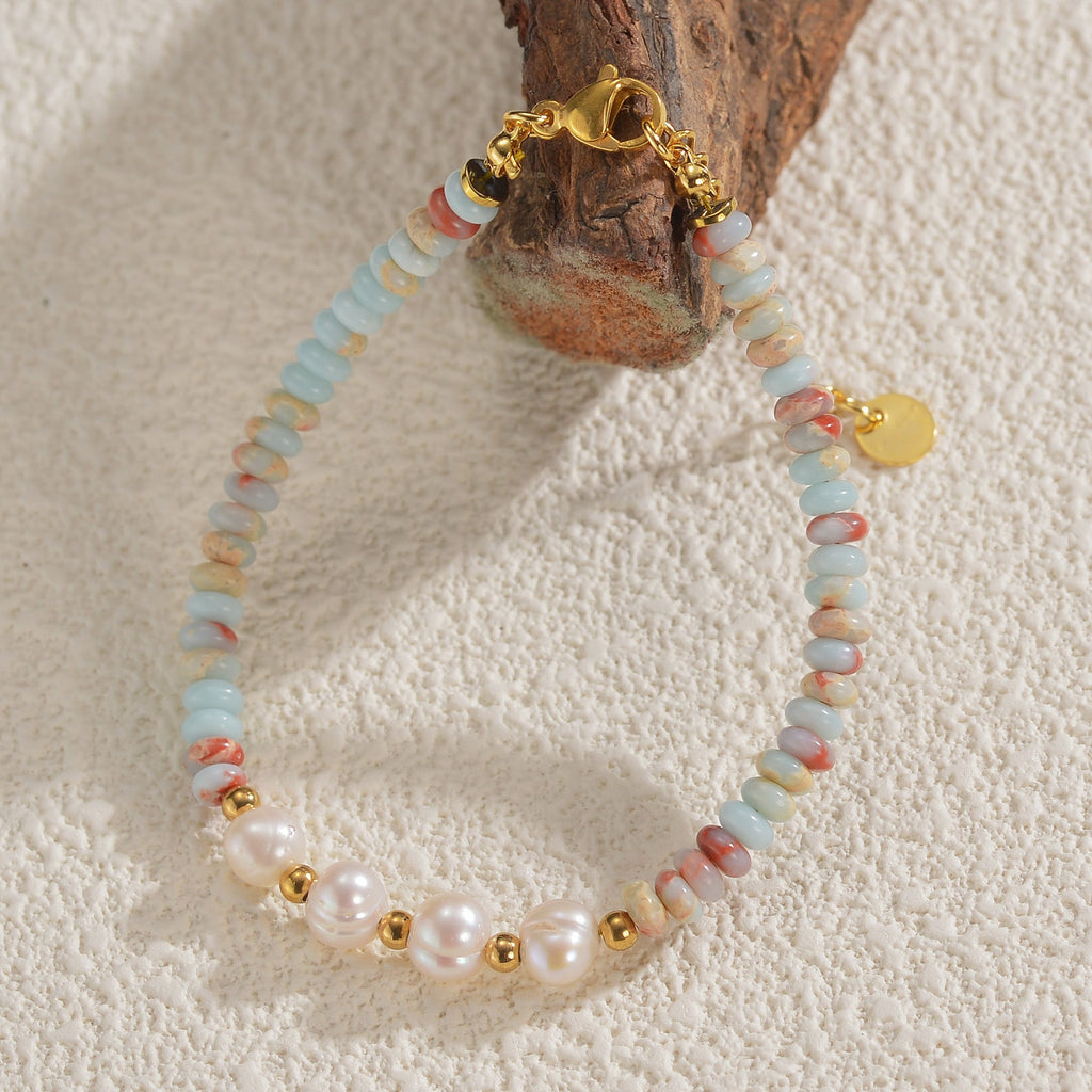 Bracelet femme perles blanches, pierres naturelles bleu clair et rose, fermoir et détails dorés.