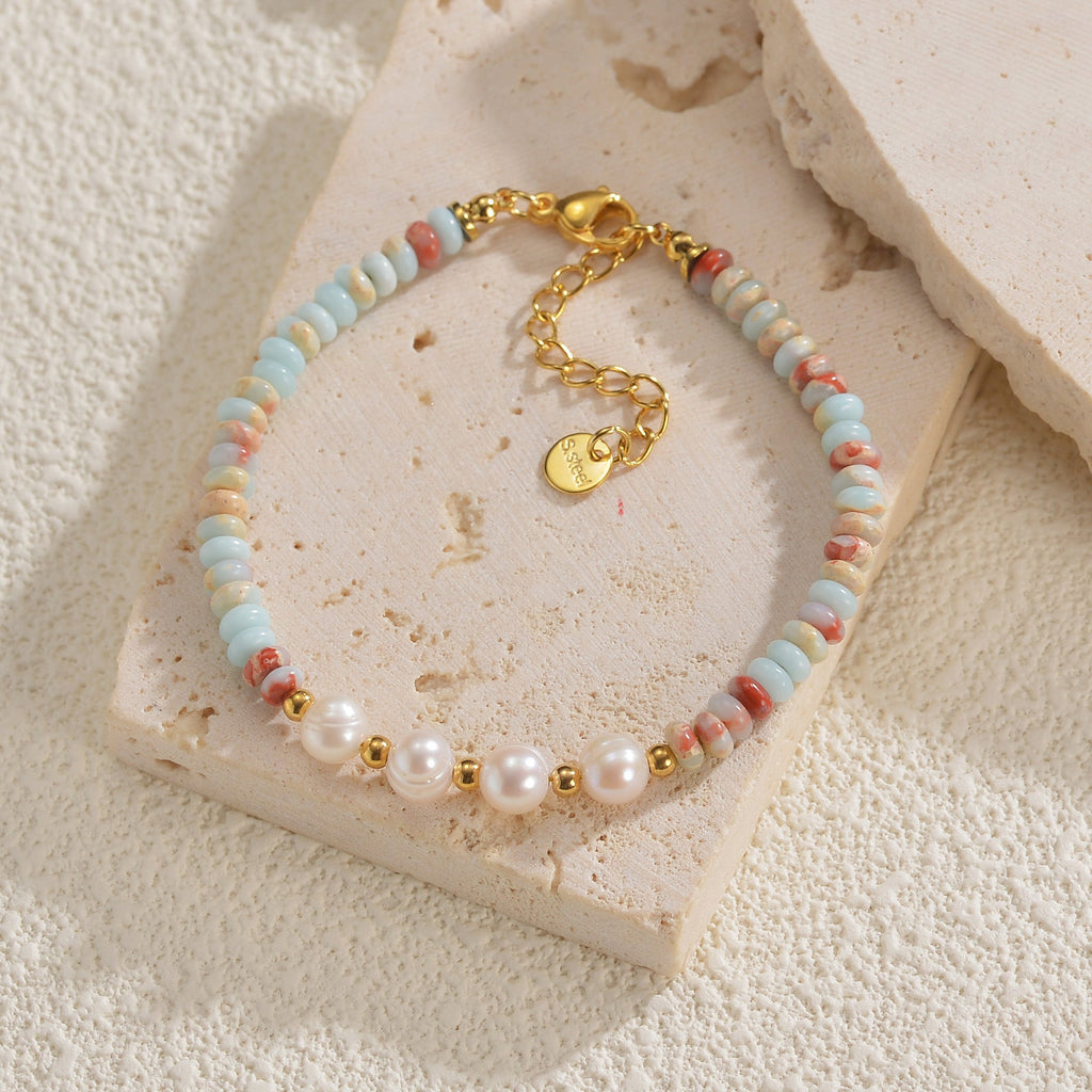 Bracelet or avec pierres naturelles bleu clair et perles blanches brillantes, fermoir ajustable.