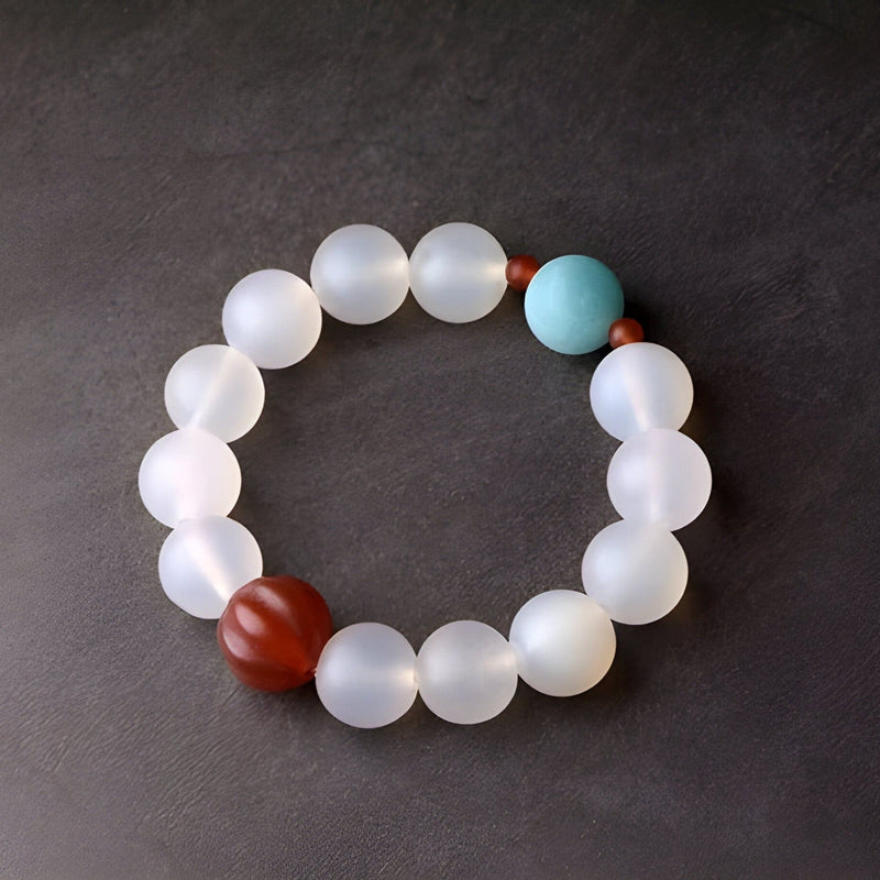 Bracelet mixte en perles d'agate blanches mates avec une perle turquoise et une perle rouge mate.