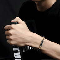 Bracelet mixte en pierres naturelles gris foncé avec perles en cuivre et élastique transparent.