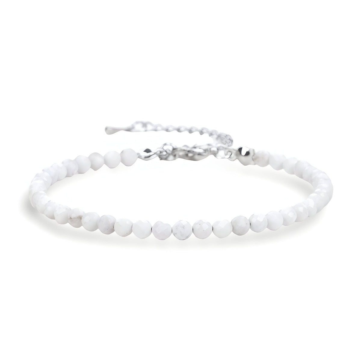 Bracelet fin en perles blanches naturelles avec fermoir argenté et chaîne réglable.