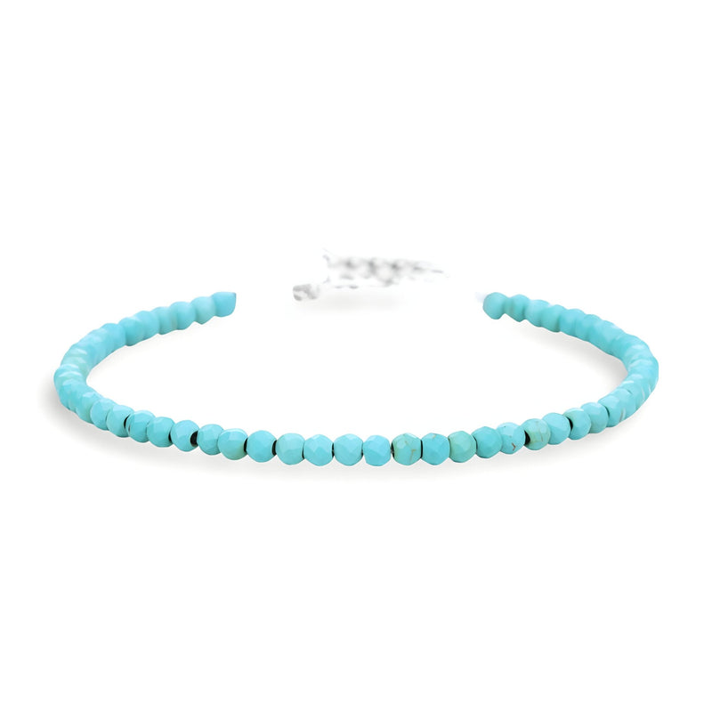 Bracelet ouvert en perles turquoise naturelle ronde et fermoir métallique argenté.