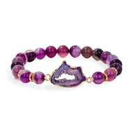 Bracelet en pierres d'agate violettes avec pierre centrale irrégulière sertie dorée.