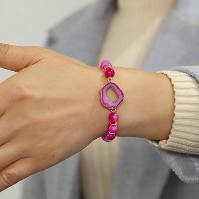 Bracelet en agate rose avec pierres irrégulières et pendentif central creux en forme organique.