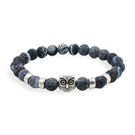 Bracelet mixte en pierres volcaniques noires avec hibou protecteur argenté au centre.