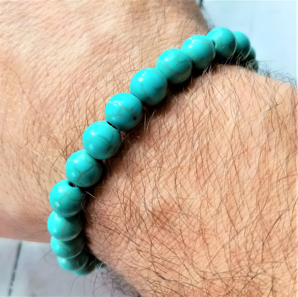 Bracelet mixte en perles turquoise lisses avec petit hibou protecteur en métal argenté.