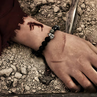 Bracelet homme en pierres volcaniques noires avec ornement tête spartiate argentée.