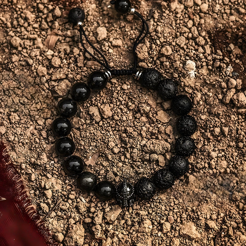 Bracelet homme avec perles noires en pierre volcanique et ornement spartiate central détaillé.