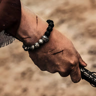 Bracelet masculin noir en pierre volcanique avec perles argentées ornement spartiate style Agron.