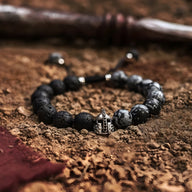 Bracelet homme perles pierre volcanique noires et jaspe gris avec ornement casque spartiate argenté.