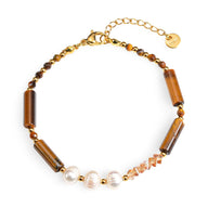 Bracelet femme avec perles blanches nacrées, pierres cylindriques œil de tigre et chaînette dorée réglable.
