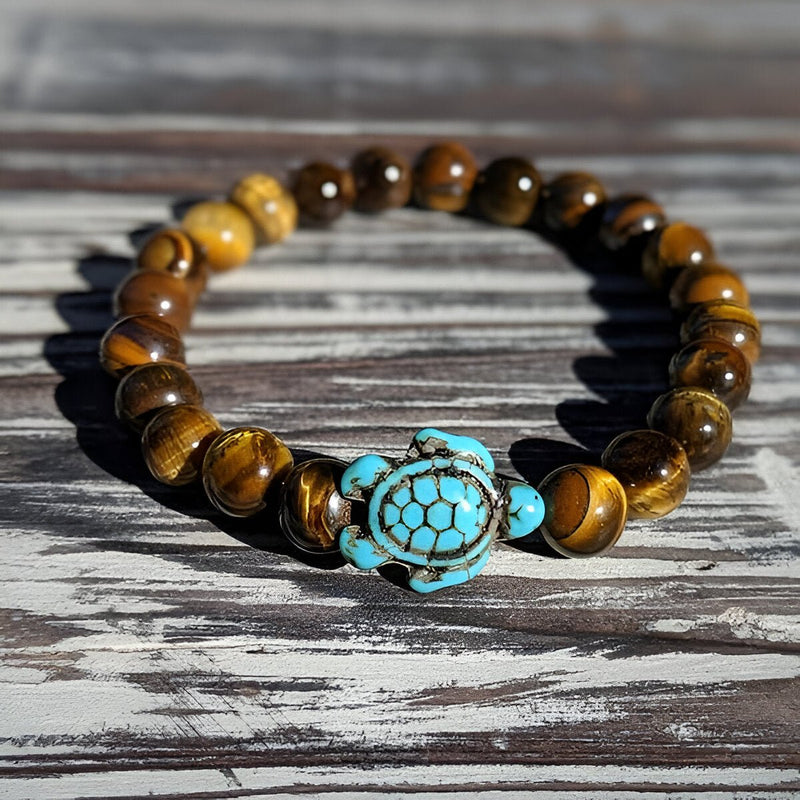 Bracelet mixte en pierres naturelles œil de tigre avec tortue turquoise sculptée au centre.