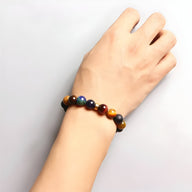 Bracelet mixte en pierres naturelles multicolores rondes, style système solaire, porté au poignet.