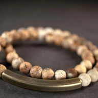 Bracelet mixte en pierres volcaniques claires et tube en cuivre brossé marron.