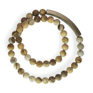 Bracelet mixte perles en pierre volcanique marron clair et fermoir cuivre courbé.