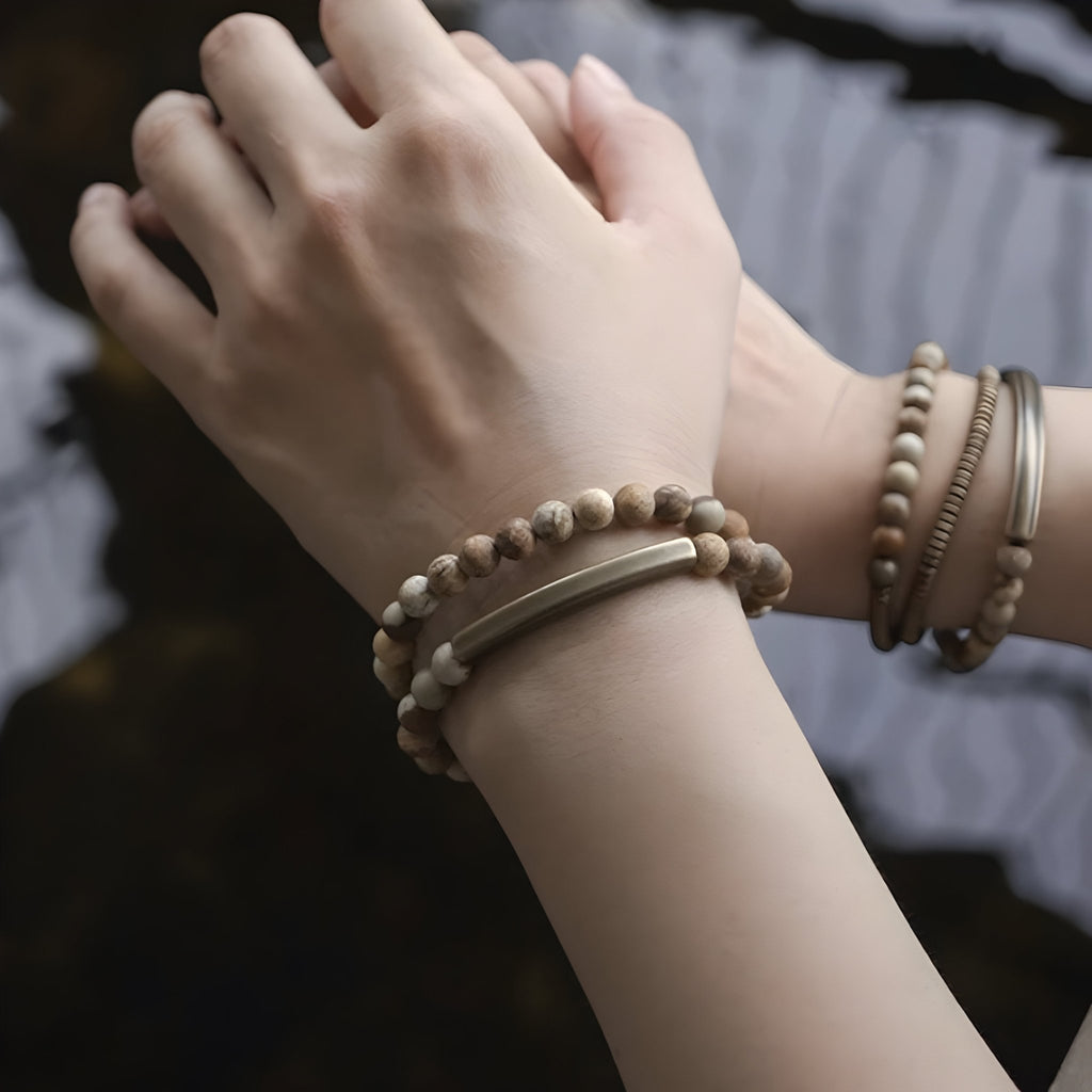 Bracelet mixte en perles de pierre volcanique claire et cuivre, style naturel et minimaliste.