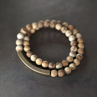 Bracelet mixte double tour en pierres volcaniques claires et cylindre en cuivre brossé.