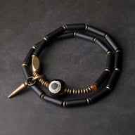 Bracelet double tour en pierres d'agate noires et cuivre, perle centrale ronde noire et blanche, fermoir aimanté en métal.