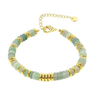 Bracelet femme en perles de cristal vert clair et anneaux dorés, fermoir chaîne réglable.