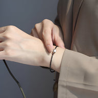 Bracelet fin noir en pierres de cristal avec tête de chat blanche délicate pour femme.