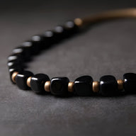 Bracelet femme en pierres d'onyx noir poli et perles de cuivre satiné, design Dorothée.