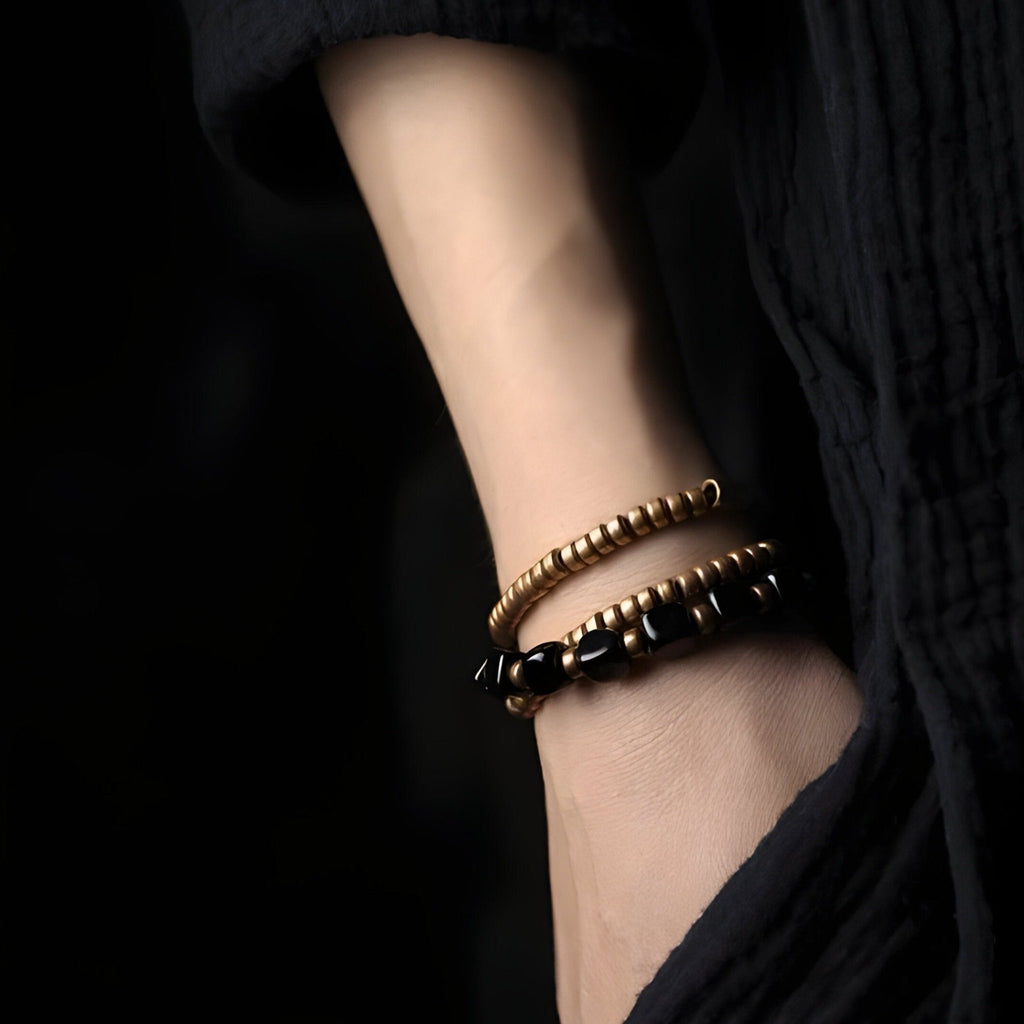 Bracelet double en pierres d'onyx noir et perles de cuivre lisse, style minimaliste pour femme.