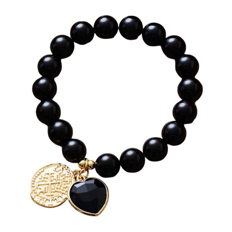 Bracelet élastique en perles noires d'onyx 10mm avec pendentifs cœur noir et médaillon doré gravé.