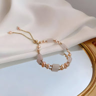 Bracelet femme en perles de quartz rose et pierres naturelles avec chaîne réglable dorée.