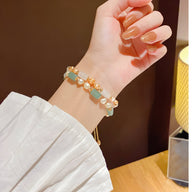 Bracelet femme en pierres naturelles aventurine et perles blanches, finition dorée, style délicat.