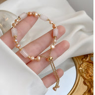 Bracelet femme en quartz rose et perles dorées avec chaîne réglable et breloque cœur.