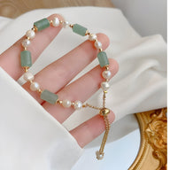 Bracelet femme avec pierres naturelles vertes d’aventurine et perles blanches rondes sur chaîne dorée ajustable.