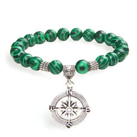Bracelet homme en malachite avec perles rondes et charm boussole argenté détaillé.