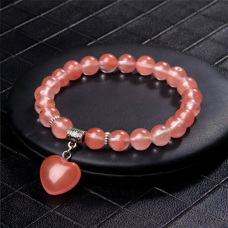 Bracelet mixte en pierres naturelles rose translucide avec pendentif cœur assorti et perles argentées.