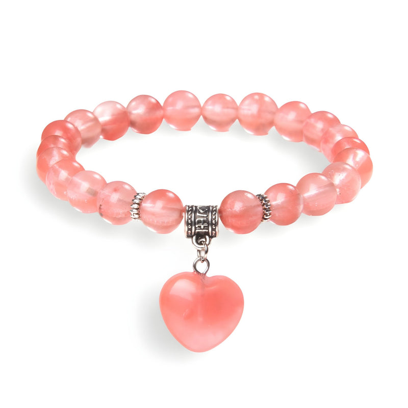 Bracelet mixte en perles rose transparent avec pendentif cœur rose en pierre naturelle et détails argentés.