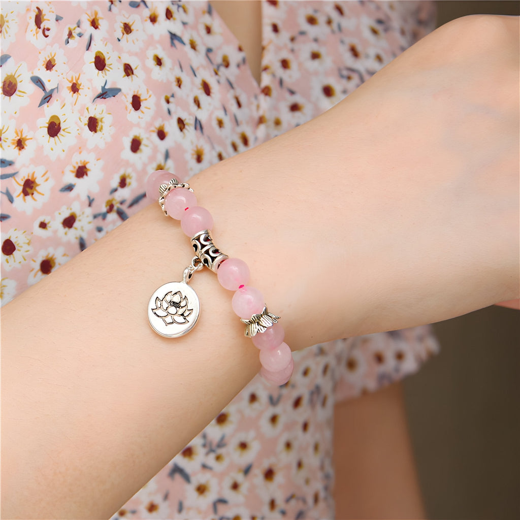 Bracelet mixte en quartz rose avec perles rondes et charme fleur de lotus argenté.
