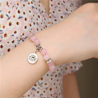 Bracelet mixte en quartz rose avec perles rondes et charme fleur de lotus argenté.