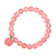 Bracelet mixte en pierres naturelles rose transparentes avec charm pomme doré et vert.