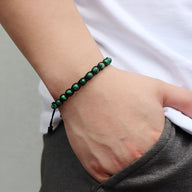 Bracelet mixte en pierres de malachite vert foncé, monté sur corde noire entrelacée.