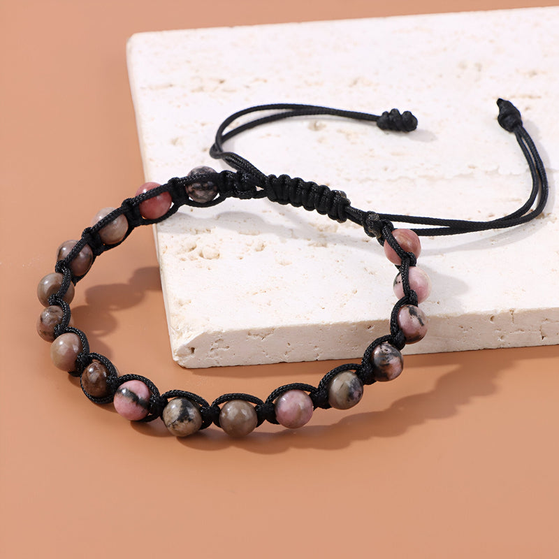 Bracelet mixte en pierres naturelles rhodonite rose et noire, entrelacé d'une corde noire réglable.