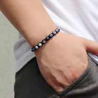 Bracelet mixte entrelacé de corde avec perles rondes bleu-gris en pierres naturelles.