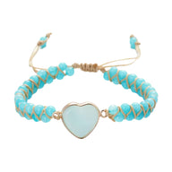 Bracelet turquoise en pierres naturelles et corde beige, cœur en pierre bleue claire au centre.