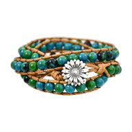 Bracelet femme multi-rangs en pierres turquoise et vertes avec corde beige et fermoir fleur argentée.