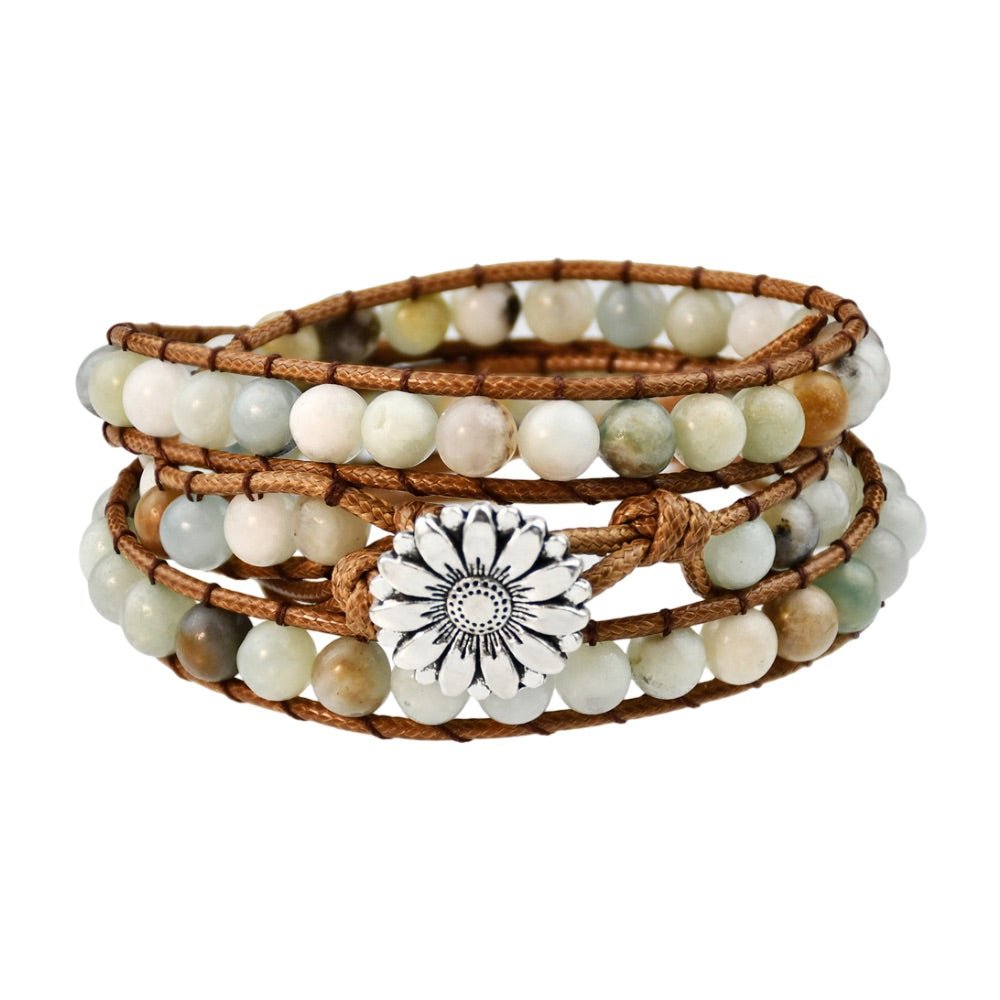 Bracelet multi-rangs en pierres naturelles vert pâle avec cordon marron et médaille fleur argentée.