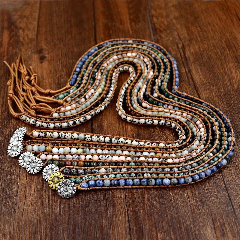 Bracelets multi-rangs en pierres naturelles variées avec cordon marron, détails argentés fleuris, style boho chic.