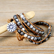 Bracelet multi-rangs en jaspe dalmatienne avec corde cuir marron clair et fermoir fleur en métal argenté.