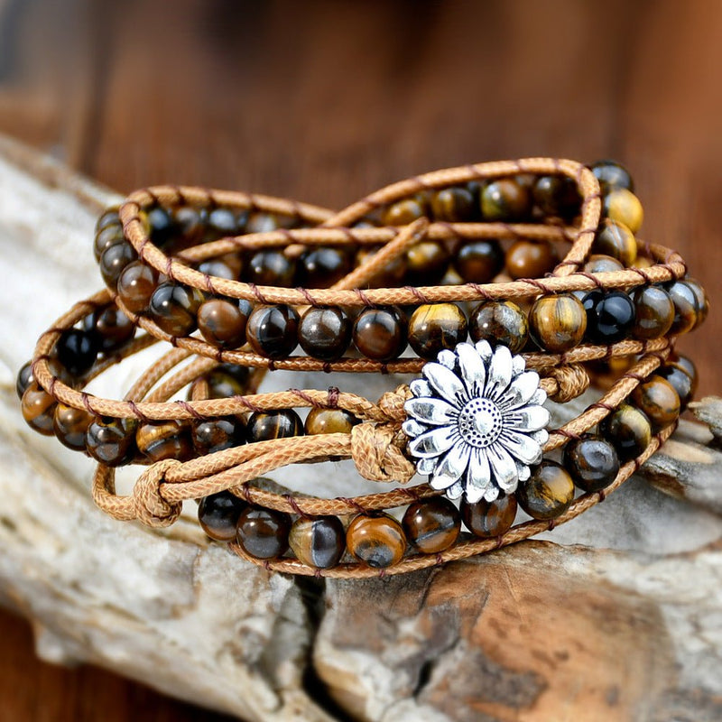 Bracelet multi-rangs en pierres d'œil de tigre avec corde beige et fermoir fleur argentée.