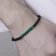 Bracelet fin pour homme en perles noires avec pierres naturelles vertes de malachite au centre.